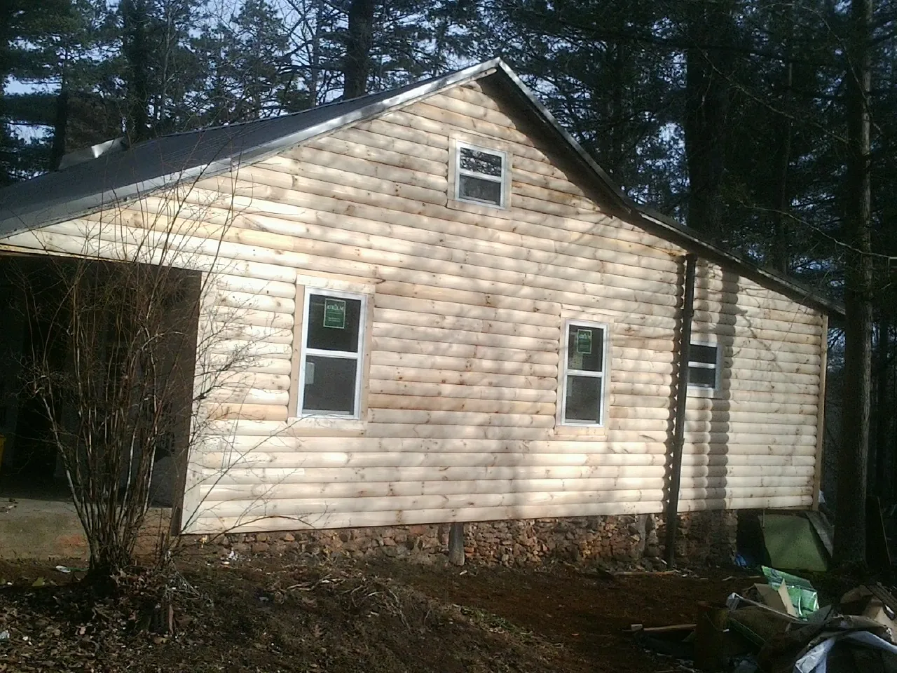 New log siding and dark metal roofing on a gable end in Strasburg