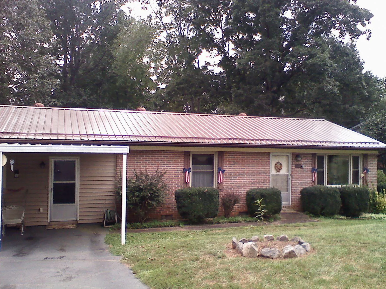 Bronze metal roof and carport on a brick ranch home — Roof Repair work by our crew in Strasburg